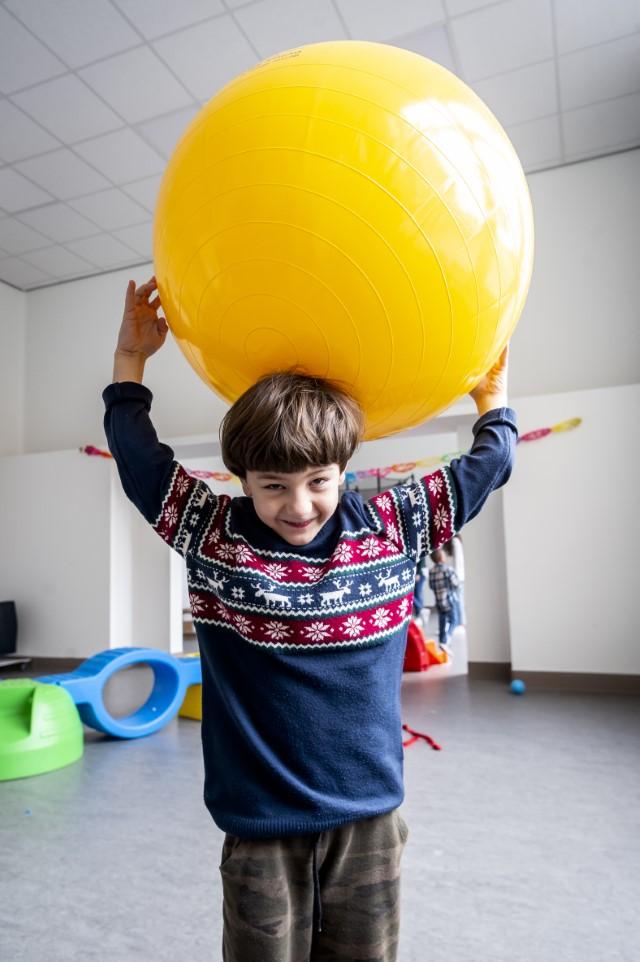 Leerexpert Capitan_Jongen houdt grote gele bal op zijn hoofd